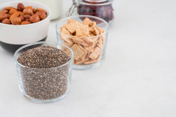 Healthy breakfast in the cups of chia, cereals, nuts and milk. The concept of healthy eating.