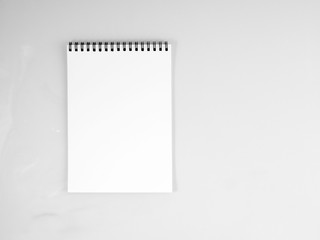 blank sheet of notebook with a spiral on a neutral gray textured  background