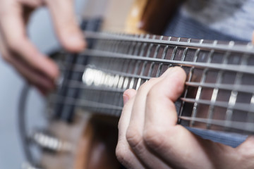 Closeup photo of bass guitar player hands, soft selective focus, live music theme