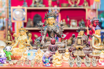 Ethnic objects on a stand. Ornamental gold statuettes representing ethnic, Indian, Hindu and Buddhist deities