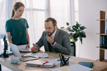 focused lawyer and client at workplace with laptop in office