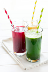 Detox drinks in glass: fresh smoothies from vegetables: beet, pumpkin and spinach on white background