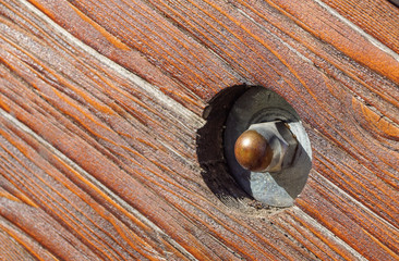 close up of old rusty screw head on rustic wooden beam