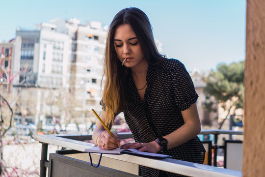 Woman with notepad on balcony