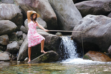 Country girl fishing in a mountain river