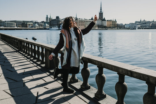 Beautiful young woman taking some pictures from her travel to Stockholm in Sweden from a beautiful view from the old city. Having fun and relaxed time. Lifestyle photography.