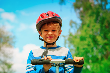 Fototapeta na wymiar happy little boy with helmet riding scooter