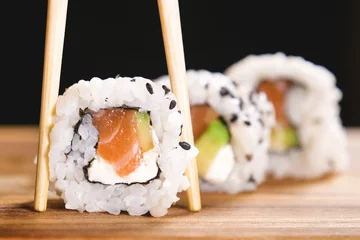 Fotobehang Sushi bar Macro-opname van sushi, sashimi, uramaki en nighiri. typisch Japans gerecht bestaande uit rijst, zalm of tonijn, garnalen en viseieren gedrenkt in soja. Concept: Japans restaurant, sushi, oosterse traditie.