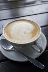 Cup of cappuccino decorated on a black table
