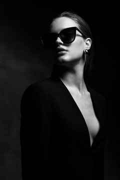 Sexy Elegant Black And White Portrait Of Young Beautiful Woman In Black Deep V Neck Jacket And Dark Sunglasses