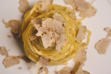 Egg pasta dish, typical Italian, with fine white truffle grated on top. Concept of: gourmet cuisine, truffles, Italian pasta, fine dishes.