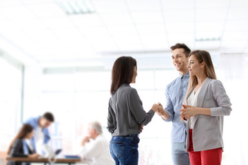Human resources manager shaking hands with applicant during job interview in office
