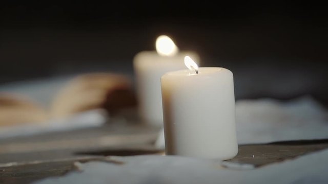 Close up shot of a light candles, books and sheets of paper with devilish signs. Dark magic, witchery stuff.