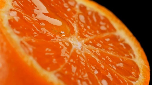juicy, refreshing tangerine in the context of which the honey flows slowly rotates, close-up