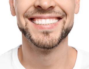 Young man with beautiful smile on white background. Teeth whitening