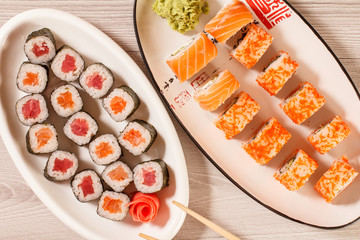 Different  sushi rolls with rice, vegetable, seafood on ceramic plates