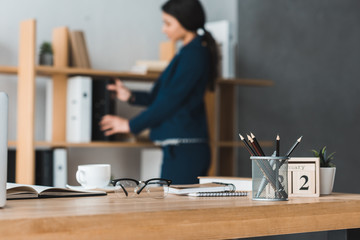 Office table in front of businesswoman stacking folders