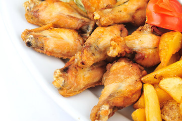 Grilled chicken wings and legs. Roasted chicken wings and legs on the plate isolated on the white background.