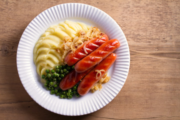Sausages, mashed potatoes, green peas and onion gravy. Homemade Bangers and Mash. View from above, top