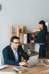 Colleagues in business suits working in modern office