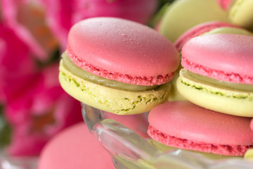 A french sweet delicacy macaroons variety closeup.macaroon colourful texture. Sweet macarons and flowers.