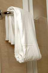 Bathroom towel. White cotton towel in the hotel bathroom for guests.