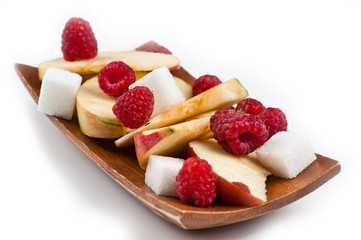 Raspberries and apple cocktail fruits mix with sugar on the wooden support  isolated on the white background.