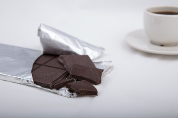 Chocolate in silver foil with black coffee..