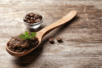 Handmade natural body scrub and coffee beans on wooden background