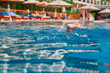 Obraz premium Concept of entertainment in the pool. Child dived into pool. Sticking out water the heel. Humor.