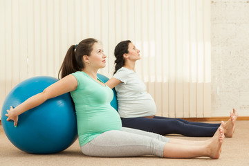 Beautiful pregnant women doing yoga with a ball