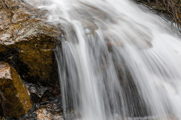 Fototapeta na wymiar Waterfall from snow melt in the mountains of Madrid, Spain