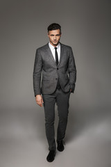 Full length portrait of successful businessman wearing business suit posing on camera with serious...