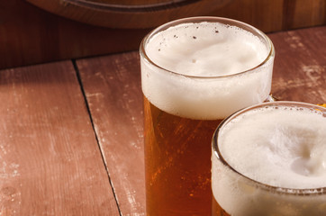 Fresh and cold beer in glass. Tasty beer concept on wooden background.