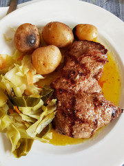 fried meat with baked potatoes and cabbage
