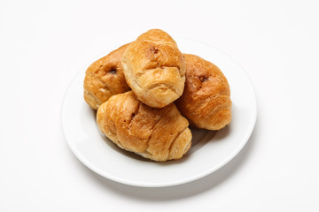 Fresh croissant in a white plate on a white table