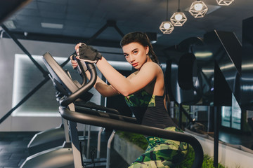 Fitness girl is working out with stepper. Strong brunette with curly hair doing aerobics on...
