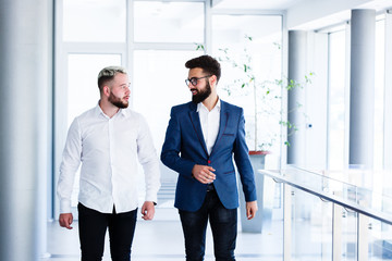 Young Business Colleagues Discussing While Walking