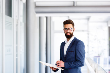 Fototapeta premium Young Businessman Posing While Writting On Some Paperwork