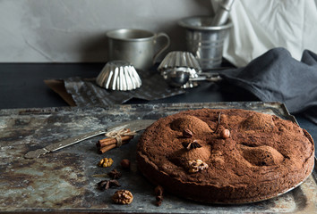 Chocolate cake with pears stewed in red wine, hazelnuts, walnuts. Traditional dessert.