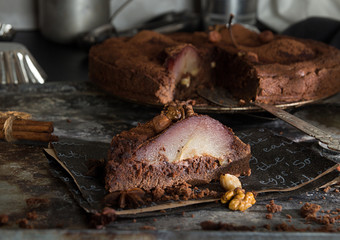 Chocolate cake with pears stewed in red wine, hazelnuts, walnuts. Traditional dessert. Top view.