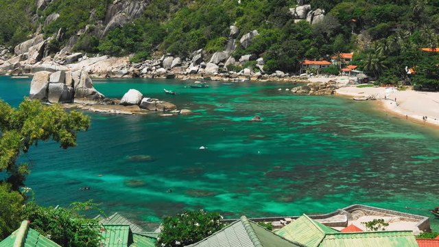 Tanote Bay on sunny day. Rippled ocean water over beautiffull Coral Reef. Tourist tan onthe beach. Divers practice in the blue bay. Koh Tao, Thailand