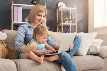 Young mother working and spending time with baby