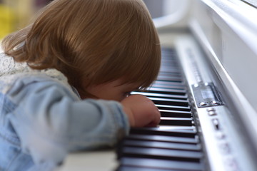 Little cute baby plays piano