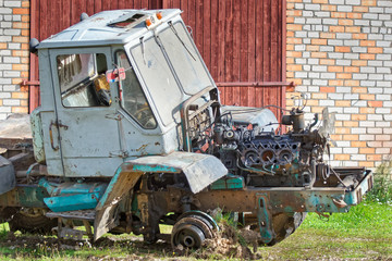 Fototapeta premium Old disassembled tractor with removed engine compartment hood and dismantled engine