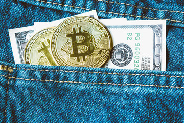 Golden bitcoins and large stack of money in the pocket of old vintage indigo stonewashed jeans. Concept of choice between crypto currency and physical money. Modern trendy color