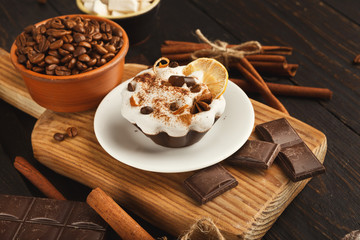 Various sweet treats: cakes and chocolate bars on dark rustic ta