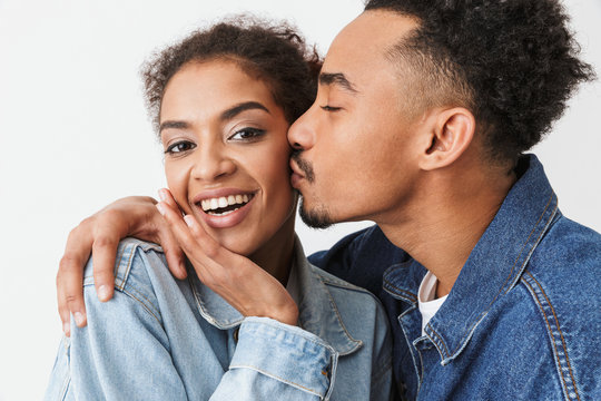Pleased african man kissing his smiling girlfriend