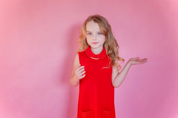 Little cute sweet smiling girl in red dress standing on pink colourful pastel trendy modern fashion pin-up background