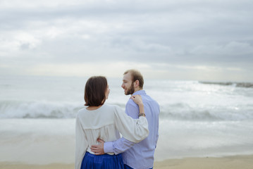 Fototapeta premium A loving couple, man and woman enjoying summer vacation on a tropical paradise beach with clear sea ocean water and scenic